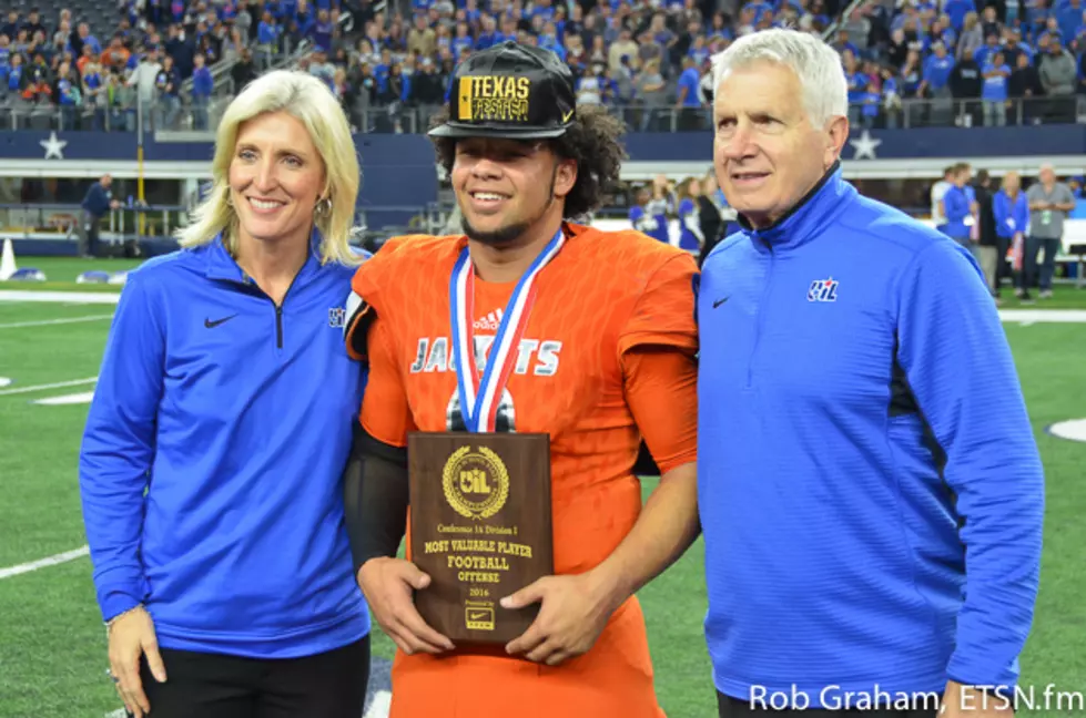 Mineola quarterback Jeremiah Crawford (center) poses with the Offensive MVP trophy alongside UIL Director of Athletics, Dr. Susan Elza (left) and UIL Executive Director, Dr. Charles Breithaupt following Mineola's 35-14 win over Yoakum, Thursday in the Class 3A Division I championship game at AT&T Stadium.